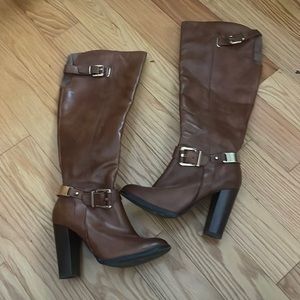 Knee high brown heeled boots.